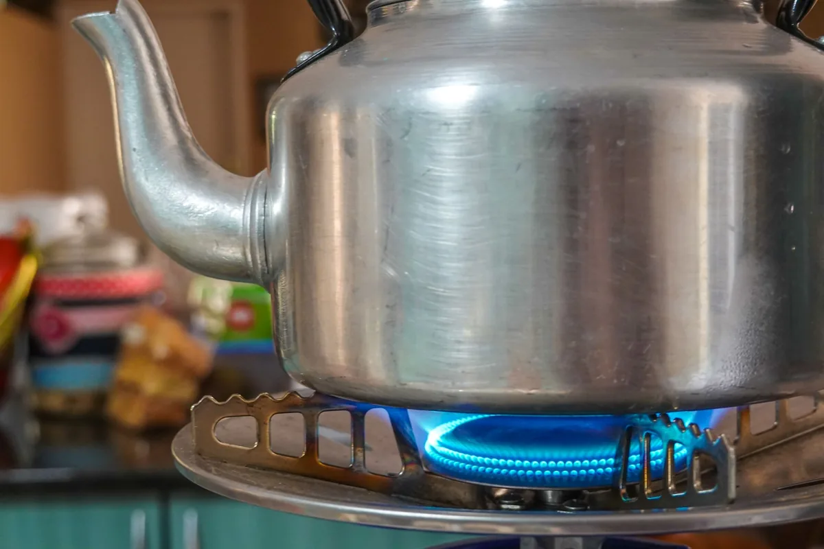 A gas hob burner lit under a pan