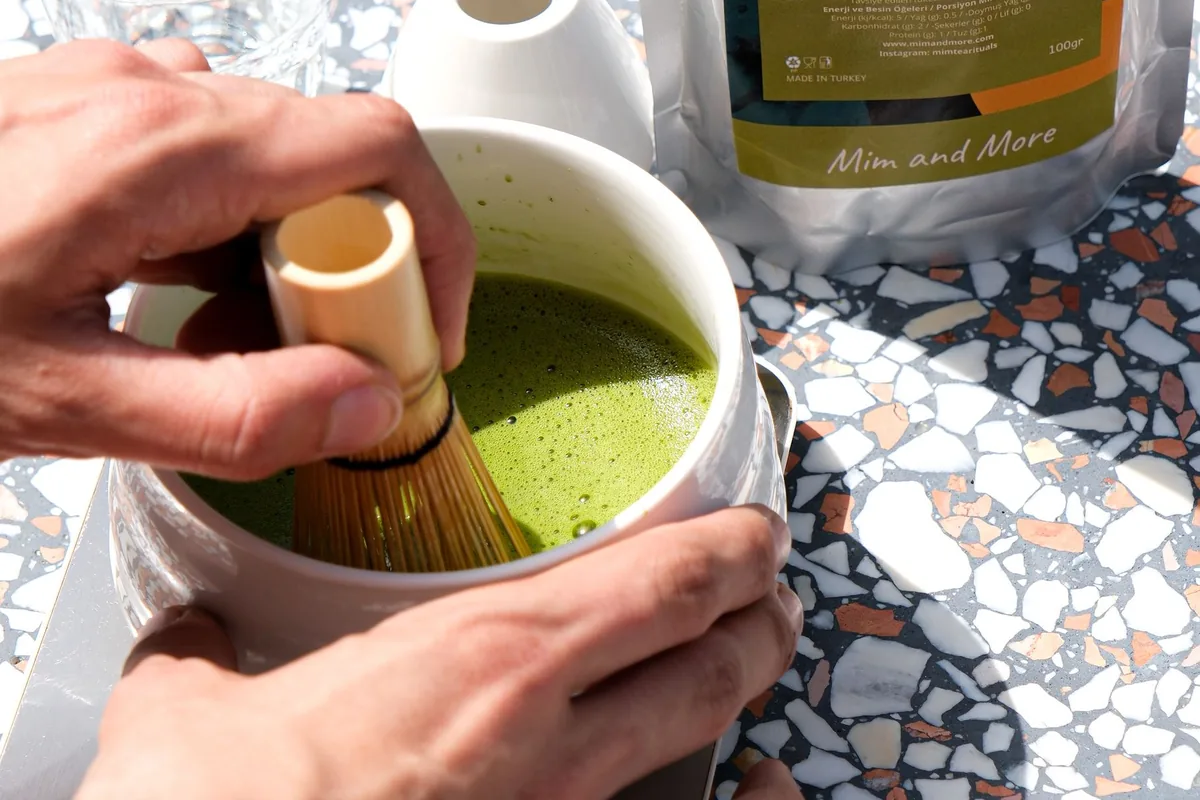 A matcha latte being whisked