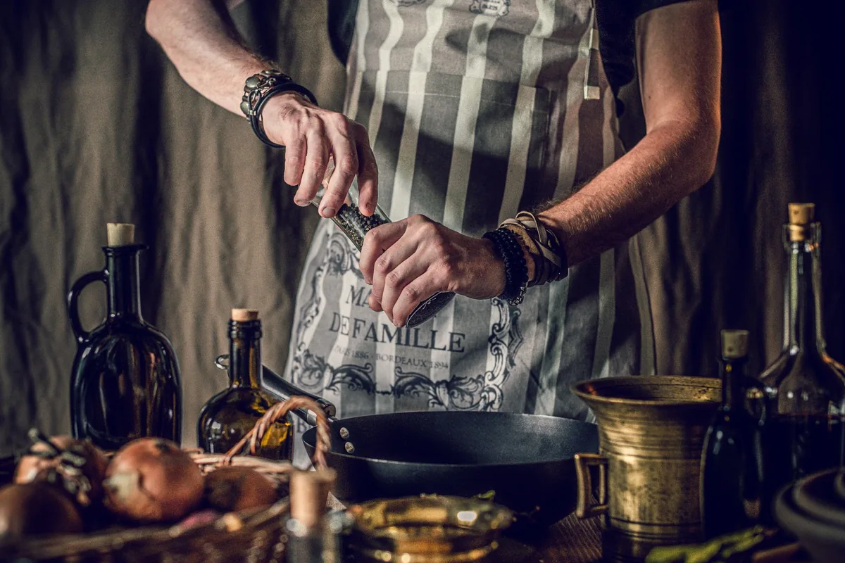 A pan being oiled with a cloth