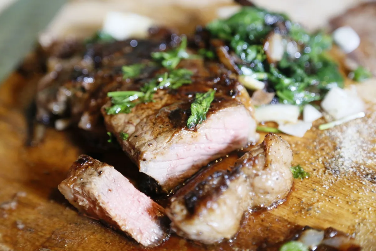 A rested steak sliced to show an even pink