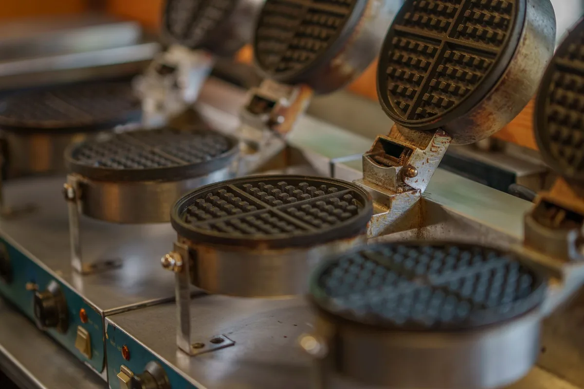 A waffle iron closed on a counter