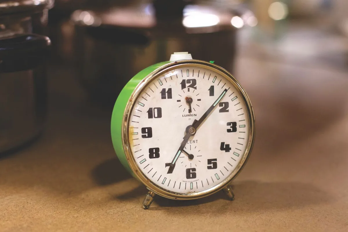 Retro alarm clock beside kitchen pots