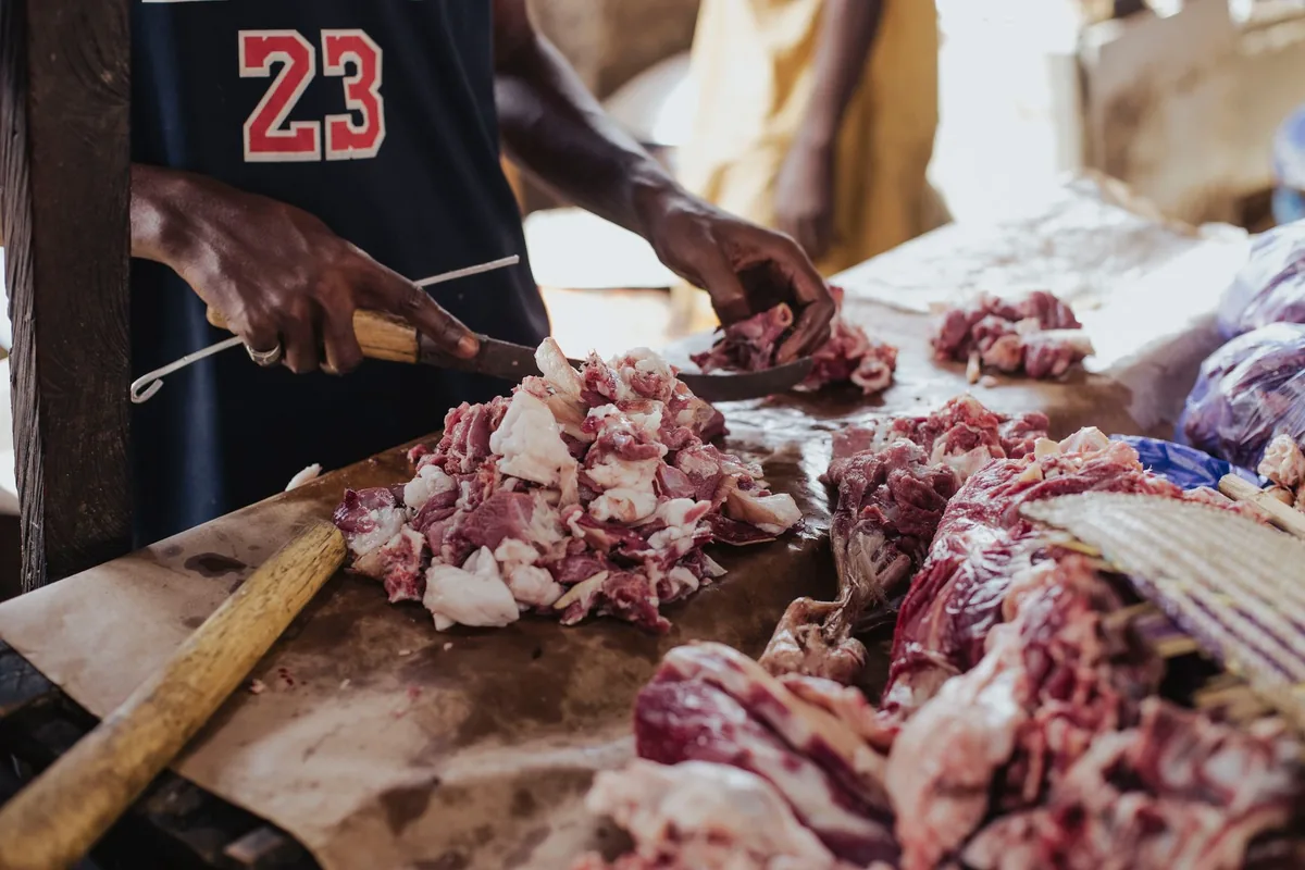 Butcher cutting fresh meat with a cleaver