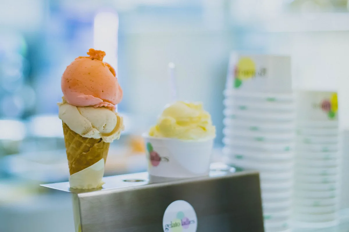 Vanilla and fruity gelato scoops in a cone