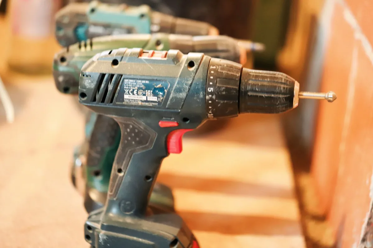 Cordless drill and screws laid out on a worktop