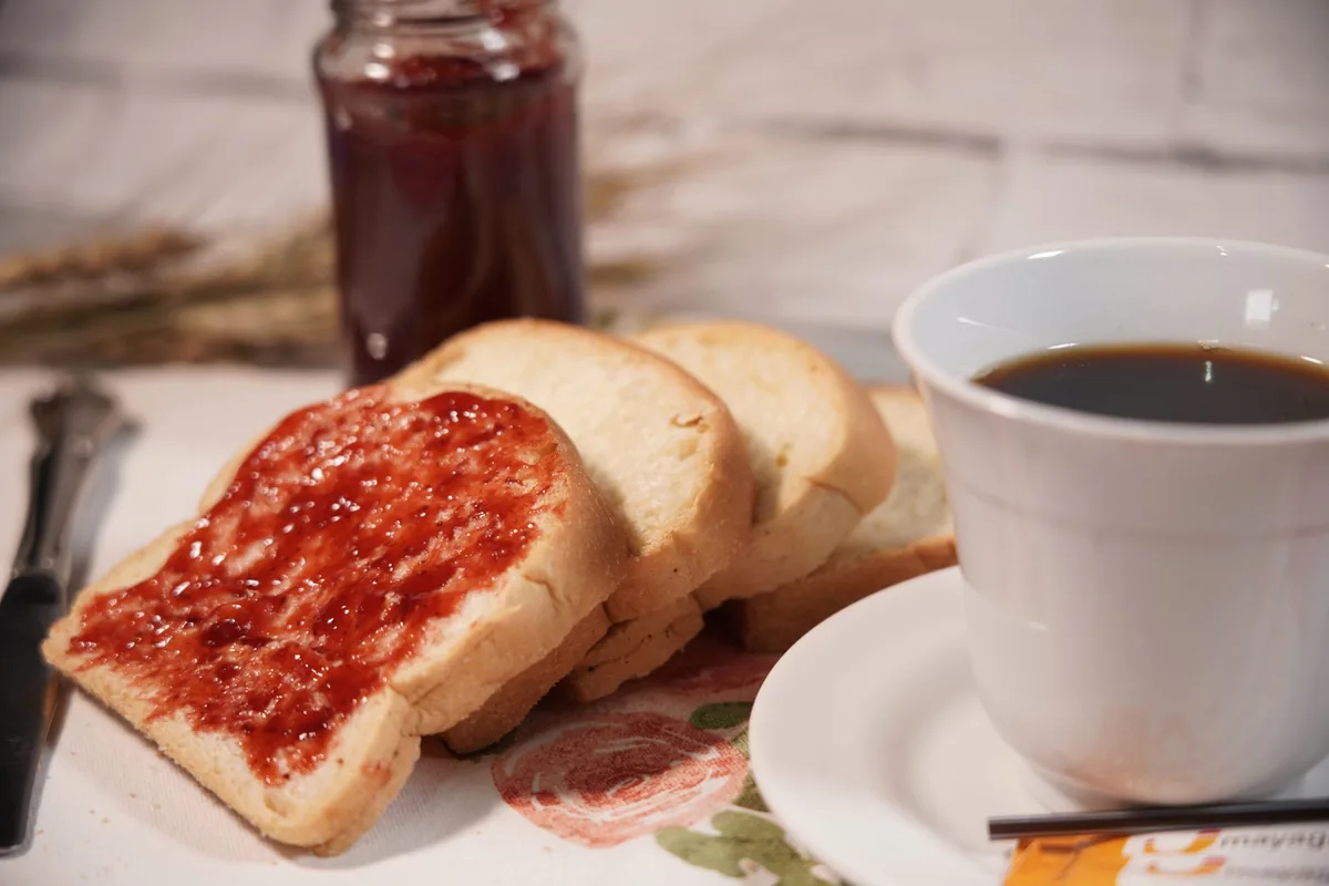 Toast with strawberry jam and a cup of coffee
