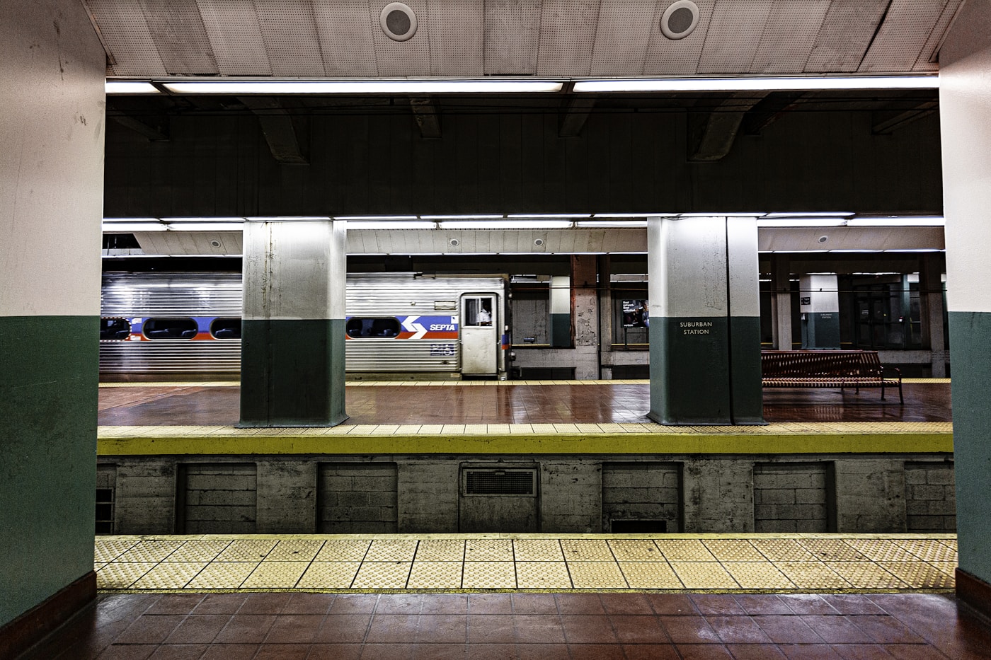 Empty elevated train platform with train arriving