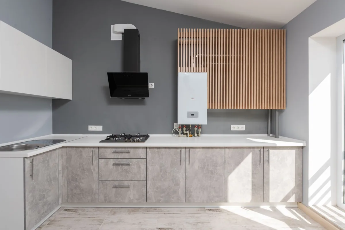 Finished kitchen with a stainless chimney hood above the hob