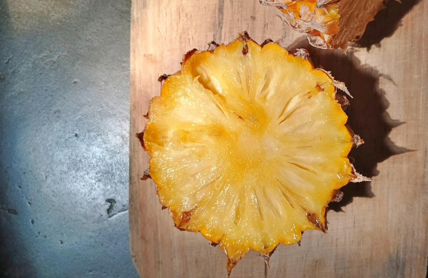 Fresh pineapple slice on a wooden cutting board