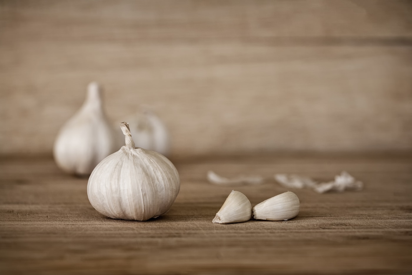 Whole garlic bulb and cloves on a wooden table