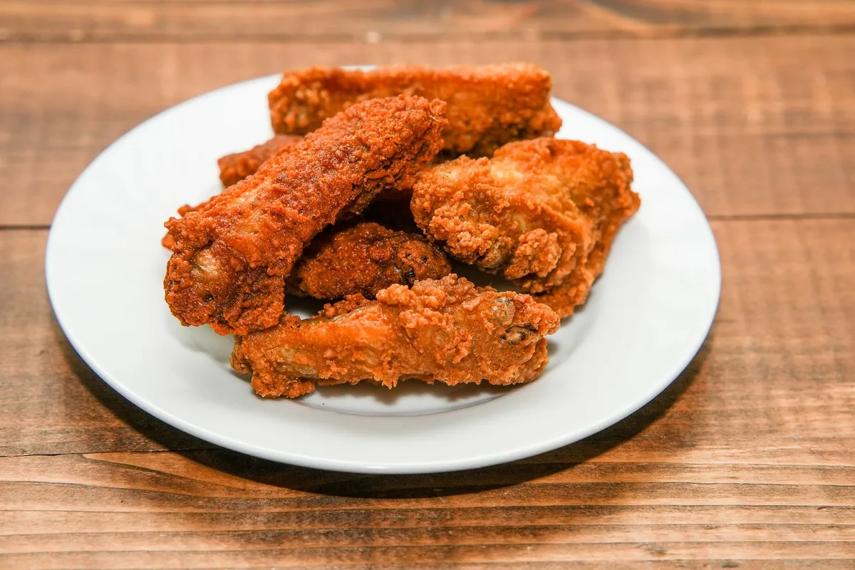 Golden crispy chicken wings on a white plate