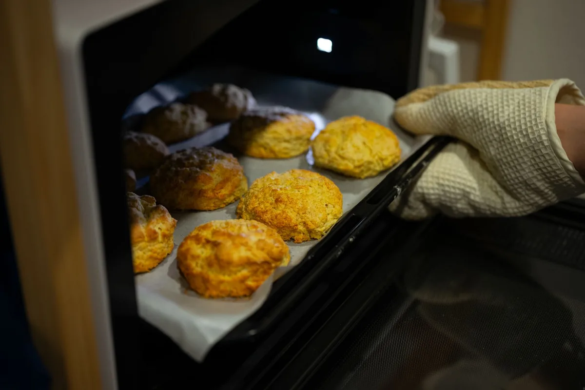 Fresh biscuits being taken out of an oven