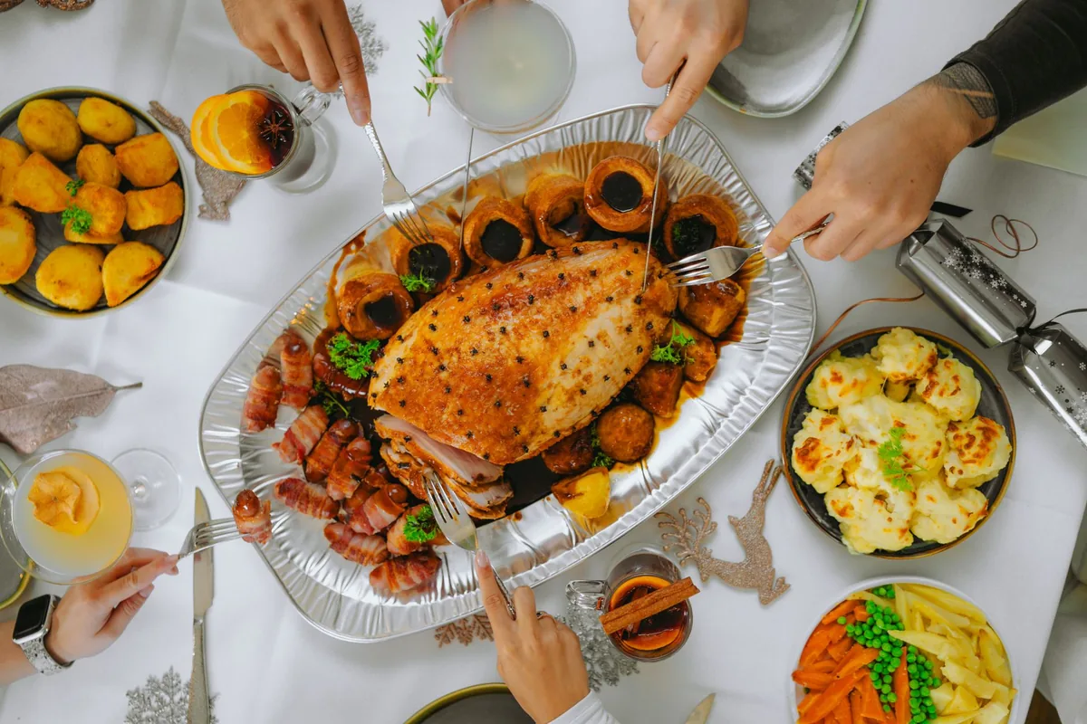 Festive holiday dinner table with roast turkey and side dishes