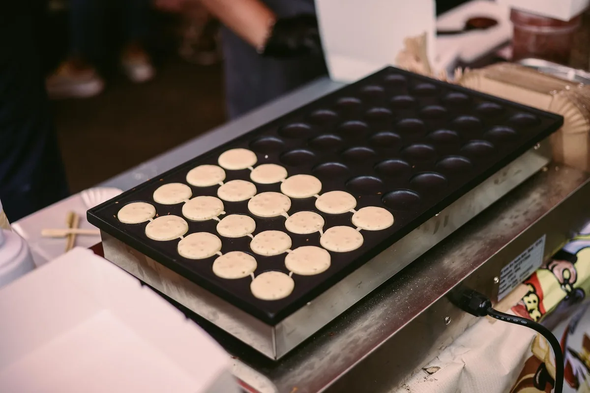Mini pancakes cooking on a griddle