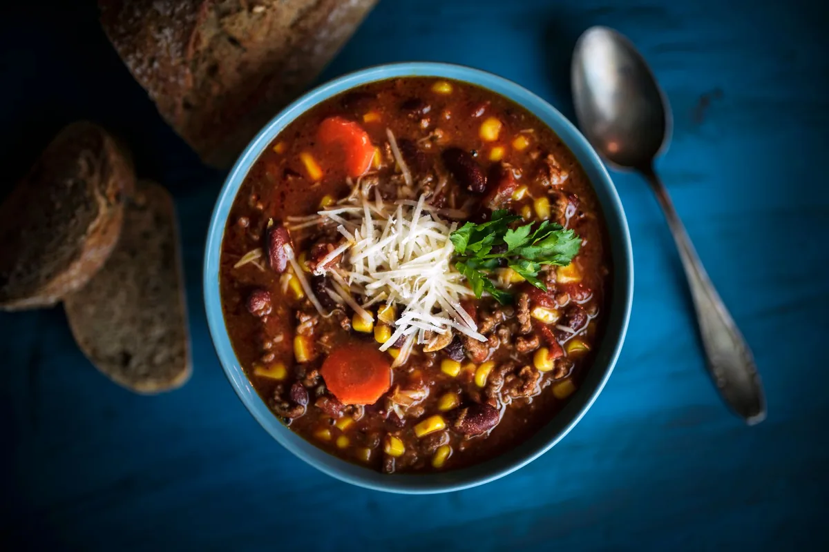 Homemade beef chili served with fresh bread on a rustic table