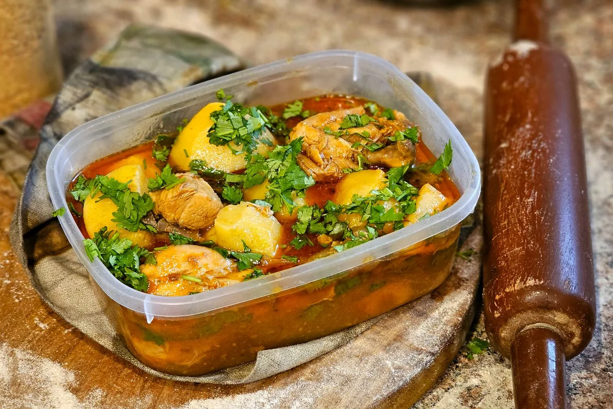 Homemade chicken stew with herbs and vegetables in a pot