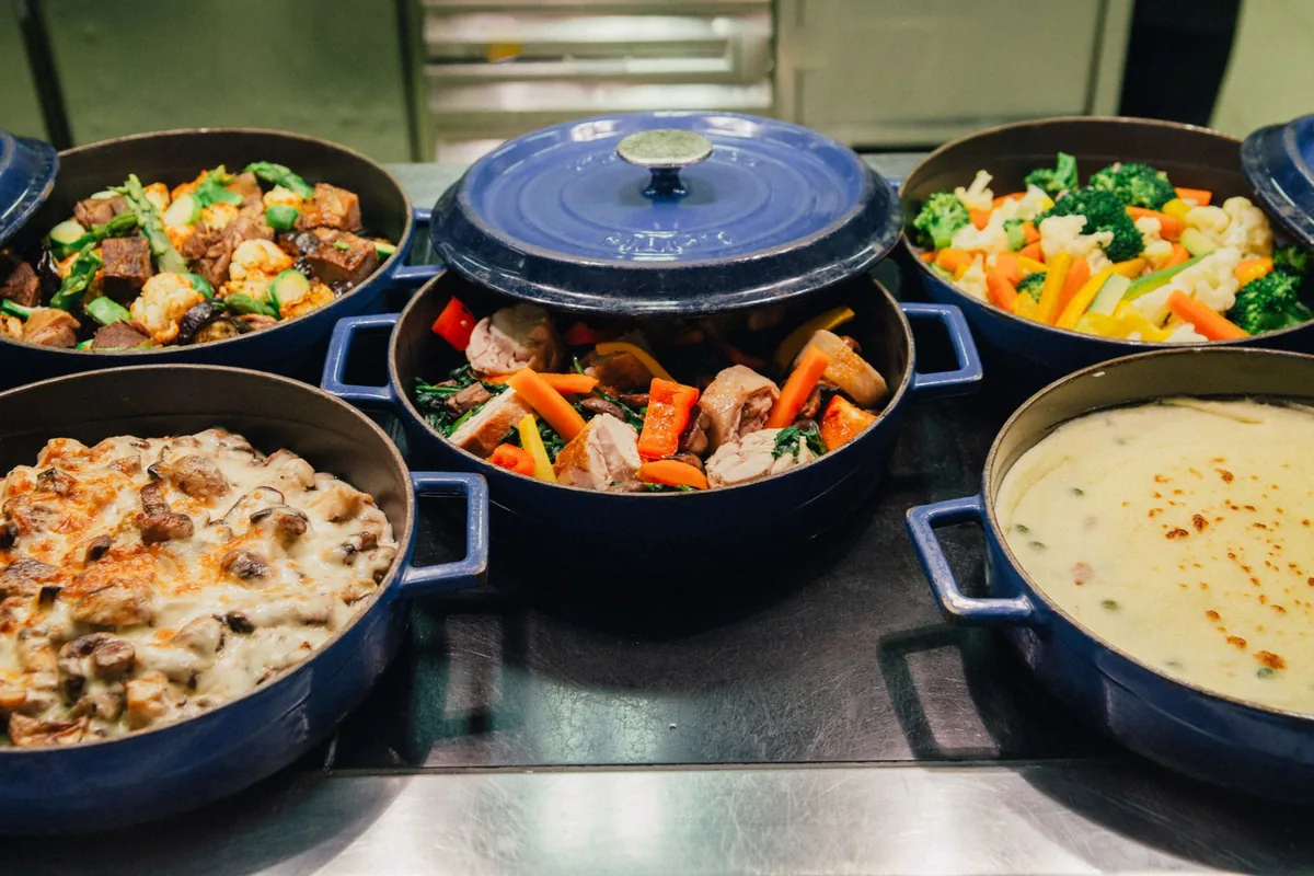 An array of dishes in blue cooking pots