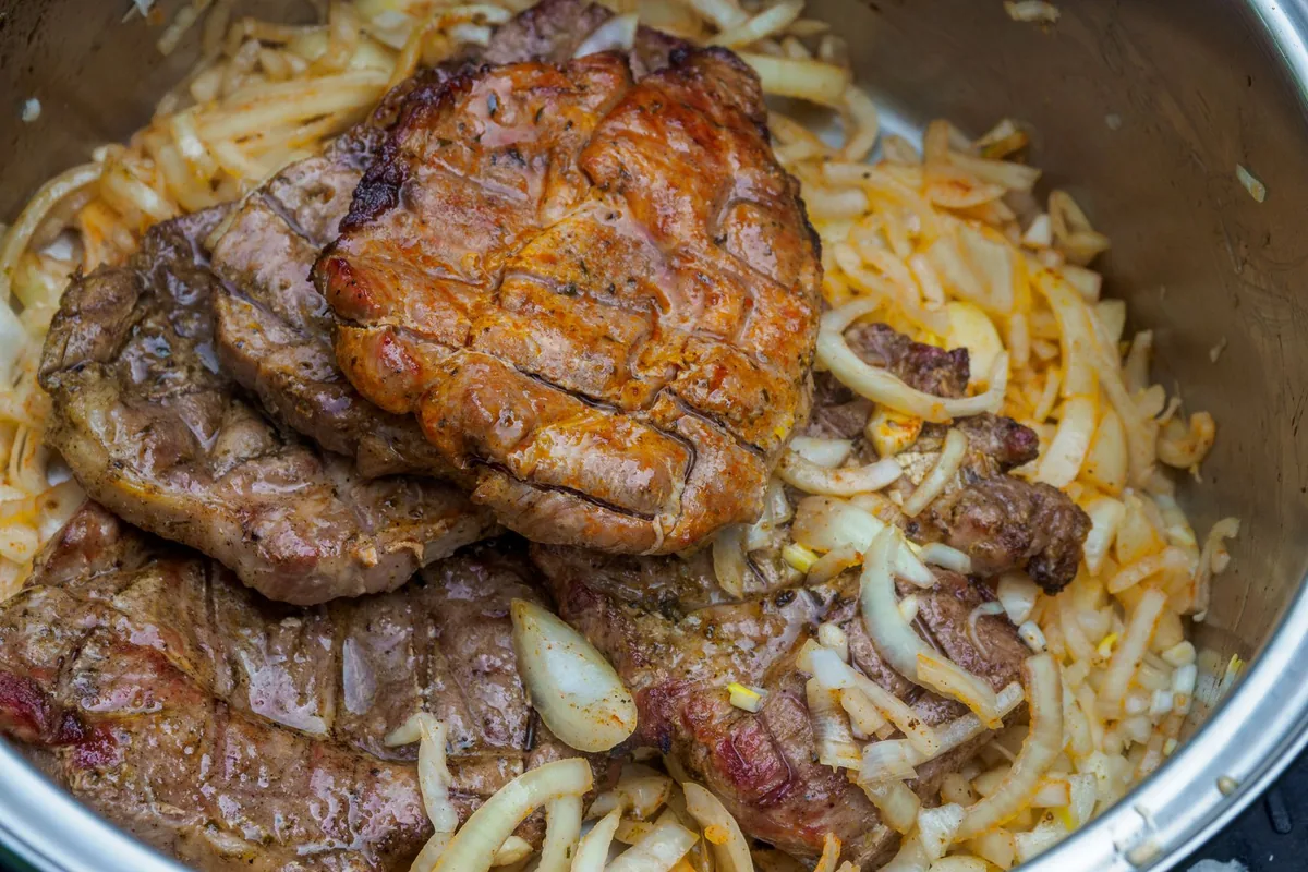 Onions and carrots browning in a pot
