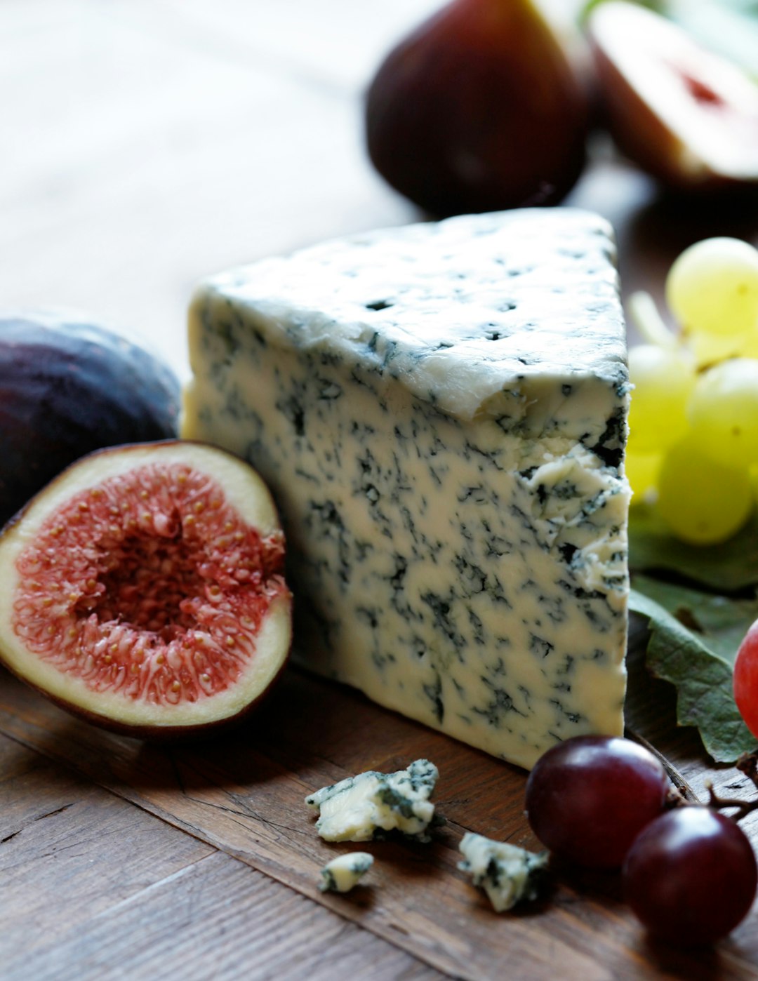 Wedge of blue cheese with figs and grapes, the cheese used in our Buffalo Chicken Calzone
