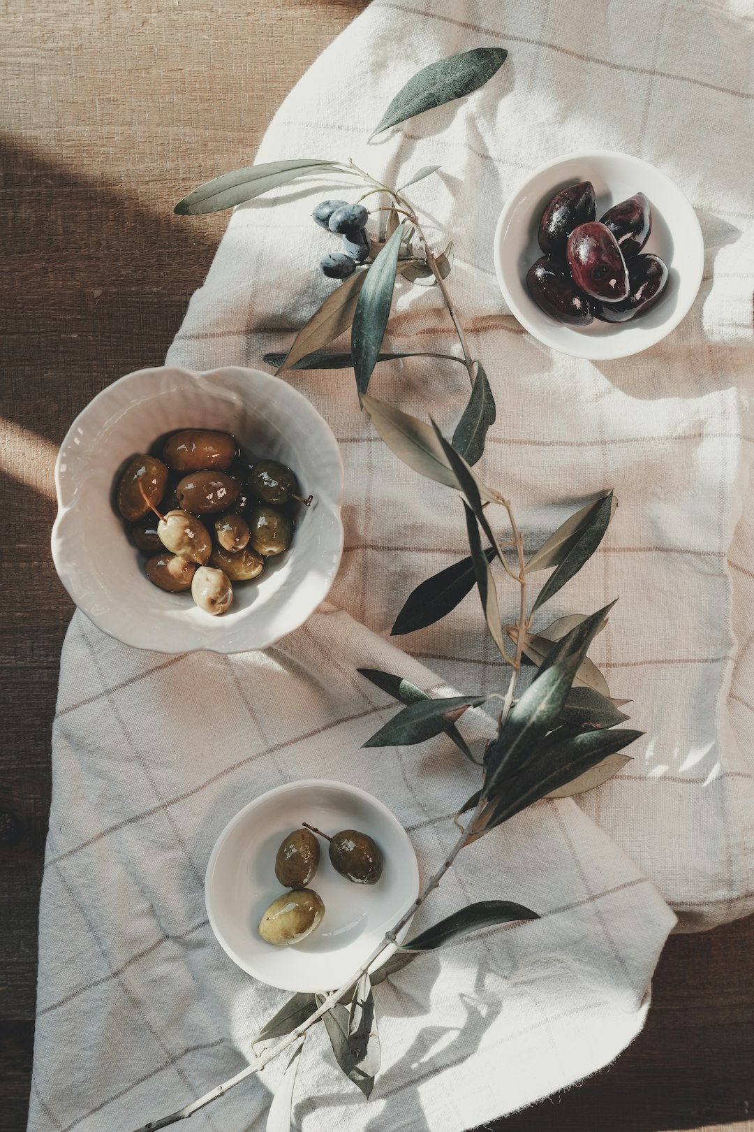 Small bowls of olives on a linen cloth