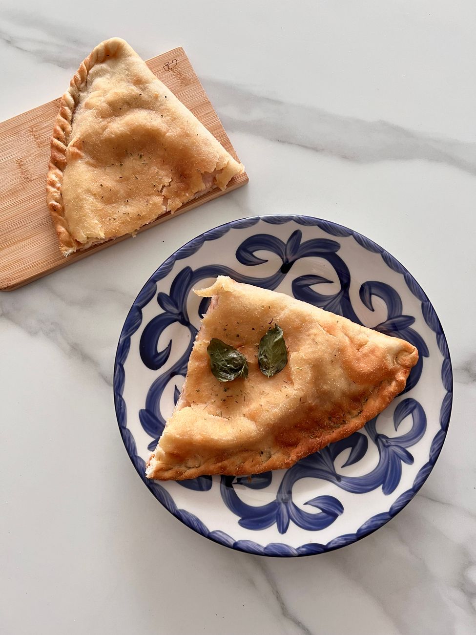 Baked calzone served on a decorative blue and white plate