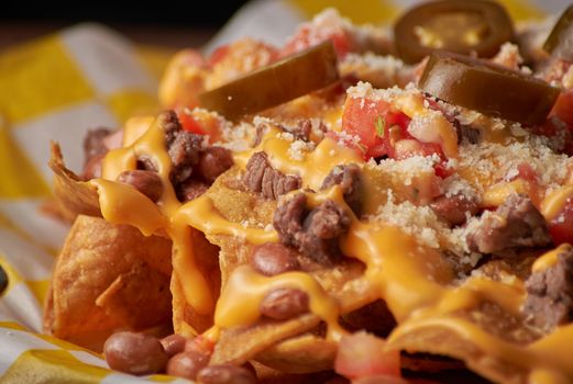 Close-up of carne asada nachos with cheese and jalapeños