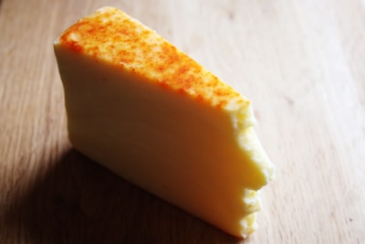 Wedge of melted cheese on a wooden surface