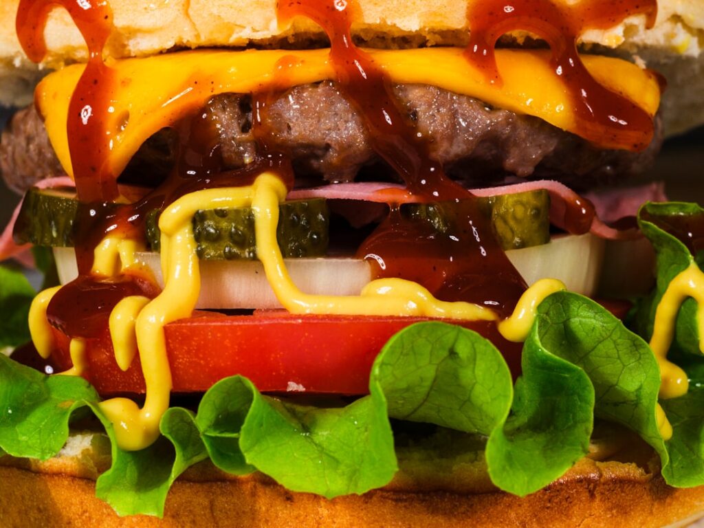 Loaded cheeseburger with lettuce, tomato, pickle, onion, and cheese