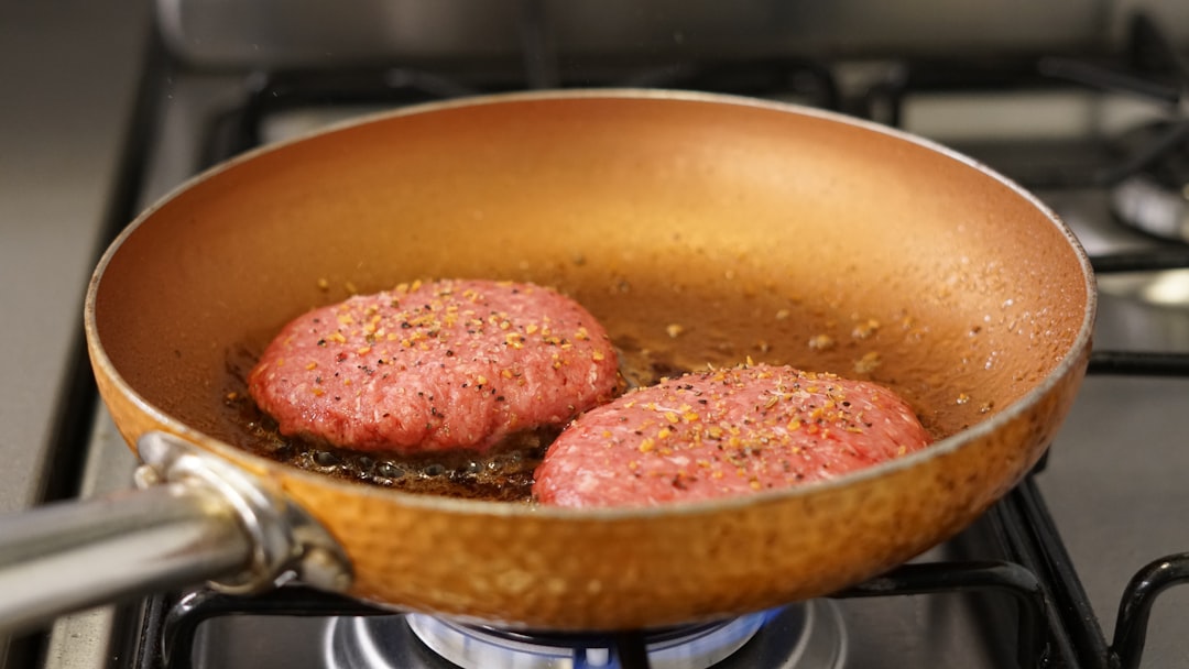 Beef patties cooking in a pan