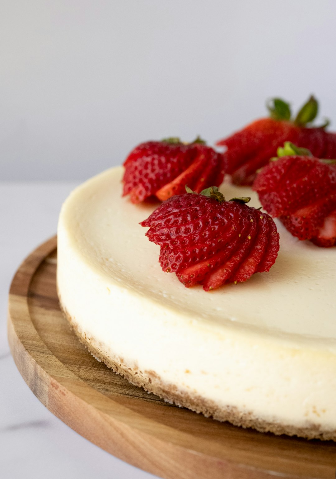 Whole cheesecake topped with fresh strawberries