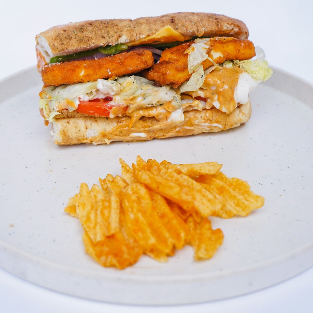 Chicken cheesesteak sandwich with melted cheese, served with waffle fries