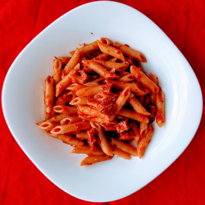 Ziti pasta with marinara sauce on a white plate
