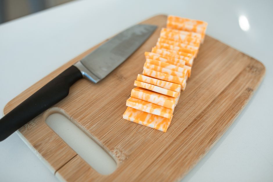 Sliced colby-jack style cheese on a wooden cutting board