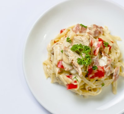 Creamy alfredo pasta with red peppers and parsley