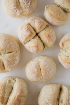 Fresh bread rolls on a white surface