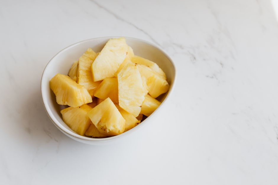 Fresh pineapple chunks in a white bowl
