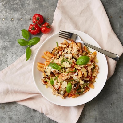 Chicken parmesan over pasta with tomatoes and parmesan