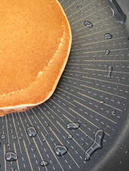 Golden pancake cooking in a pan
