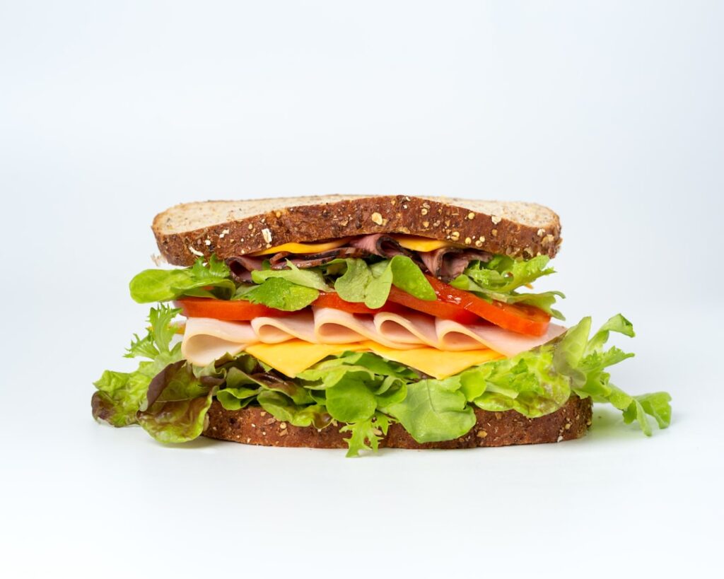 Ham hoagie sandwich with American cheese, lettuce, and tomato
