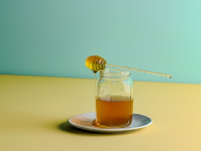 Jar of honey with a wooden dipper