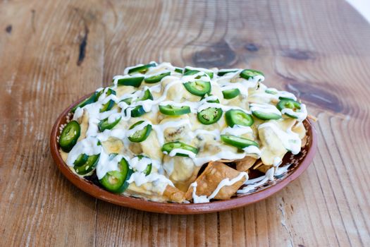 Nachos topped with melted cheese and jalapeños