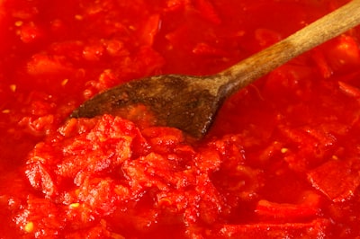 Marinara sauce simmering in a pot with a wooden spoon