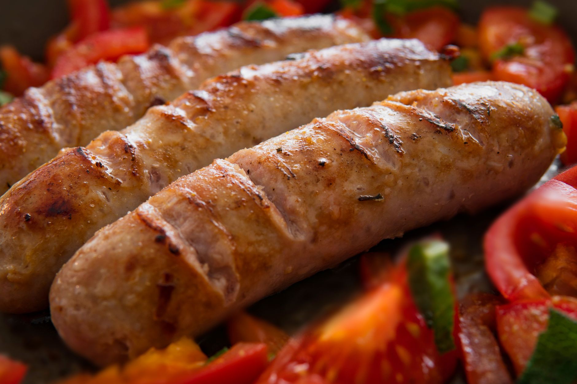 Grilled Italian sausage links with sliced tomatoes