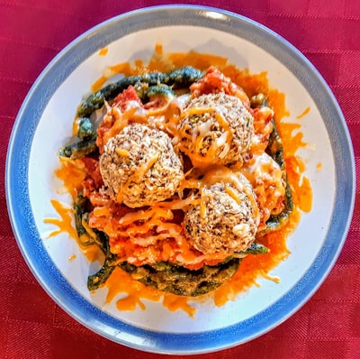 Meatballs in marinara sauce over pasta with melted cheese
