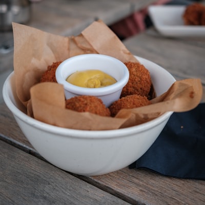 Breaded fried mozzarella sticks with dipping sauce in a bowl