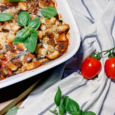 Oven baked ziti casserole with melted cheese and basil