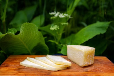 Sliced provolone cheese on a wooden board