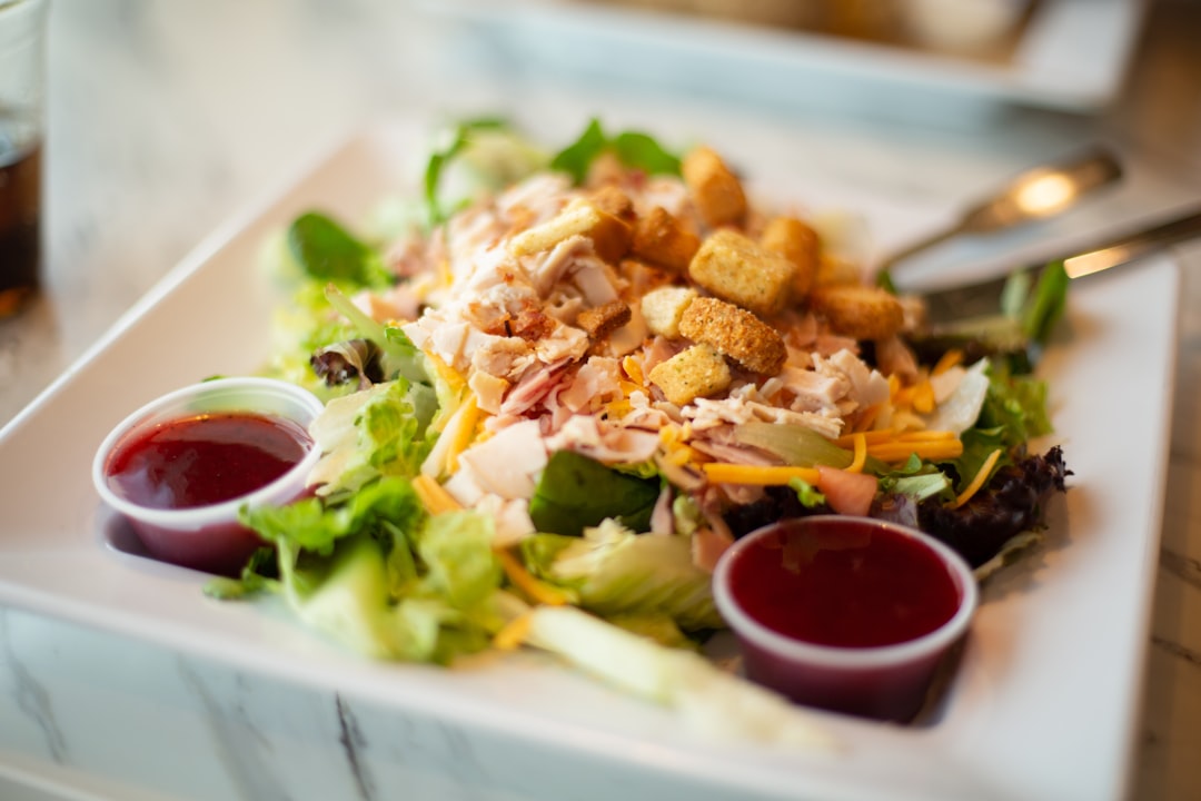 Chef-style salad with shredded meat, cheese, and croutons on a white plate