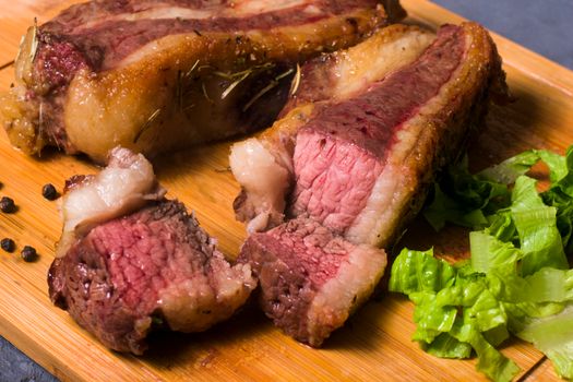Sliced grilled steak on a wooden board