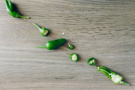 Sliced jalapeños on a wooden surface